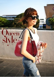Detailed view of crocodile embossed wine red tote bag with black woven handles