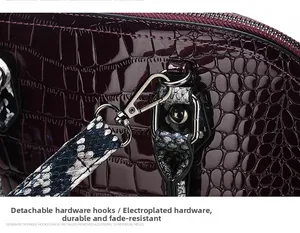 Macro detail of wine red crocodile embossed leather handbag with gold-plated metal hooks