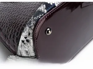 Close-up of red patent leather and crocodile embossed texture with metal feet studs