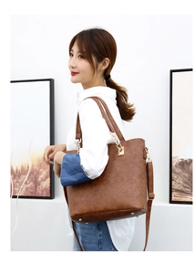 Brown leather tote bag with adjustable strap shown on a model for daily commuting style