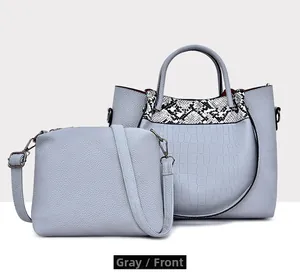 Detail view of grey litchi texture tote bag and crossbody set with snakeskin patchwork