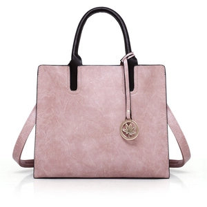 Pink vintage faux leather tote bag with brown handles and a gold maple leaf charm