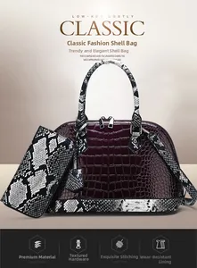 Detail of wine red crocodile embossed handbag with black and white snake skin pattern accents