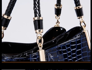 Detail of dark blue crocodile texture with golden metal ring and woven handle
