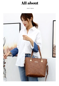 Detail of a large brown faux leather tote bag with gold hardware and removable shoulder strap