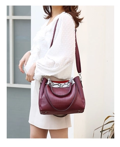 Burgundy faux crocodile handbag with snake pattern accent shown on model shoulder