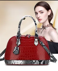 Detail of red crocodile texture handbag with snake pattern accents and metal zipper