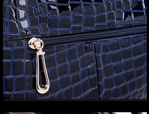 Close-up of dark blue crocodile pattern leather texture with golden metal zipper