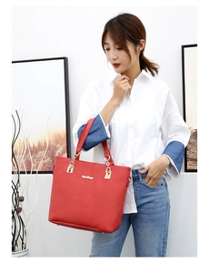 Asian model holding a large red lychee leather tote bag with elegant gold metal chain