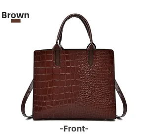Close-up of brown crocodile pattern embossed leather tote bag with sturdy handles