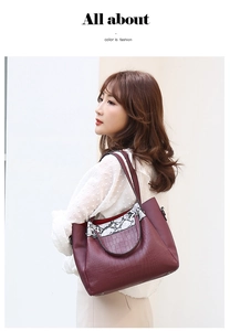 Detail of burgundy crocodile and snake skin textured bucket tote bag for women