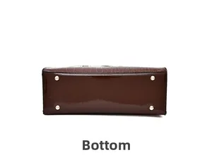 Detail of dark brown faux crocodile handbag bottom with four protective metal rivets