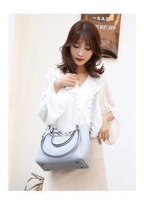 Close-up of women's crocodile pattern bucket bag with snakeskin patchwork zipper detail
