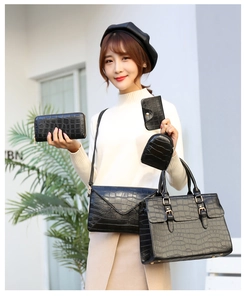 Detail of 5-piece black crocodile embossed handbag set with tote, crossbody bag and wallets
