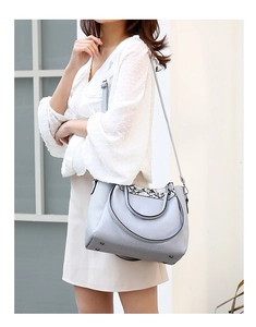 Detail of grey-blue crocodile embossed bucket bag with snakeskin trim shown on model