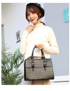 Fashionable black embossed crocodile texture handbag with gold buckles on female model