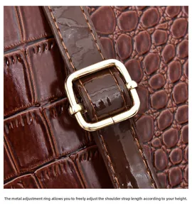 Detail of brown crocodile pattern leather with gold adjustable buckle and stitching