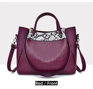 Front view of a red crocodile embossed bucket bag with snakeskin pattern detailing