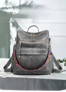 Dettaglio zaino vintage grigio con tracolla intrecciata colorata e chiusure lampo in metallo