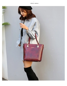Model in volledige lengte met een vintage bordeauxrode tote tas van reliëfleer