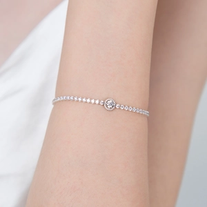 Elegant silver stainless steel tennis bracelet with halo crystal center on female wrist