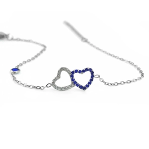 Detalle de pulsera de corazón plateada con circonitas y dijes de cristal azul oscuro