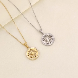 Dettaglio di ciondoli circolari color oro e argento con brillanti pietre di zircone