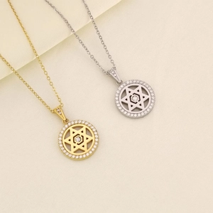 Dettaglio di ciondoli a stella tondi in oro e argento con pavé di zirconi luminosi
