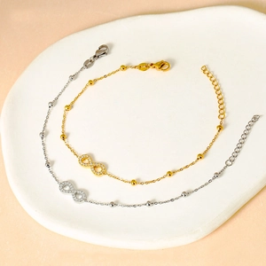 Macro detail of gold and silver infinity bracelets with micro-inlaid crystals