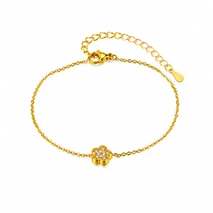 Dettaglio del bracciale in acciaio al titanio dorato con ciondolo a fiore in zircone e catena