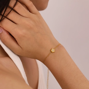 Dettaglio di un bracciale a quadrifoglio placcato oro con pietre di zircone scintillanti
