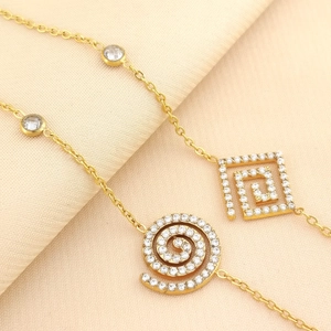 Detailed close-up of a gold-plated bracelet with shimmering heart-shaped zircon charms