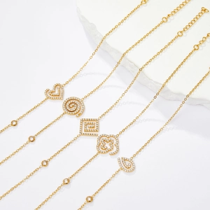 Detailed close-up of gold stainless steel bracelets with zirconia heart and clover charms