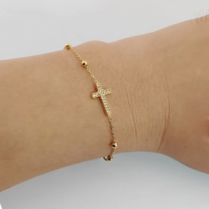 Bracelet croix en acier titane doré avec zircons et perles en métal sur poignet