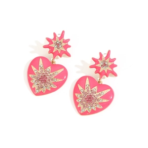 Détail de boucles d'oreilles cœur en émail rose avec motif étoile et cristaux scintillants
