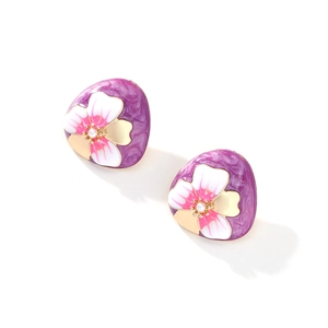 Gros plan détaillé des boucles d'oreilles fleurs en émail violet avec perle centrale