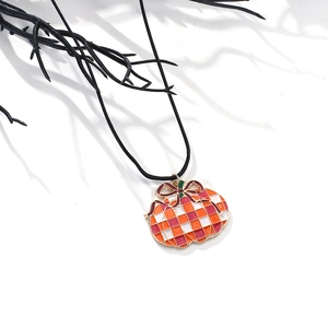 Retro Halloween pumpkin pendant necklace with orange checkered enamel and gold bow on black cord