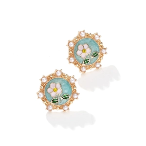 Detailed view of floral enamel earrings with pearls and vintage gold metallic edges