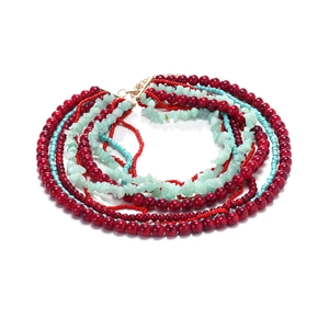 Collier multicouche de perles rouges et éclats naturels bleu clair sur fond blanc