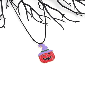 Collier citrouille d'Halloween avec chapeau de sorcière sur branches sombres