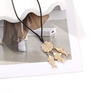 Bohemian gold seashell necklace with three fish charms on adjustable black woven cord