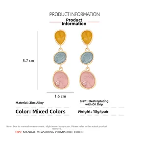Vue détaillée des boucles d'oreilles pendantes en émail dégradé avec perles