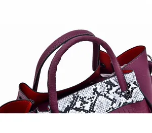 Close-up of crocodile texture leather handbag with red lining and sturdy round handle