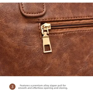 Detailed macro view of the smooth golden alloy zipper and brown textured leather handbag