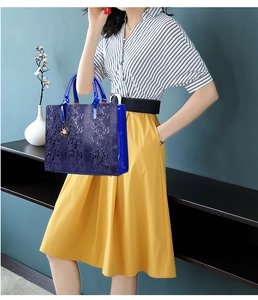 Dark blue snake pattern tote bag with metallic leaf charm shown on a model