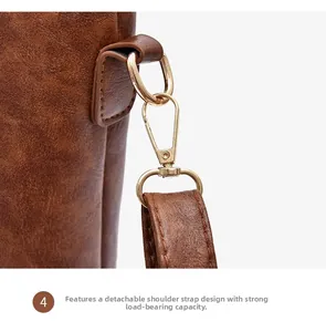 Detail of light gold swivel snap hook and textured brown leather on detachable bag strap