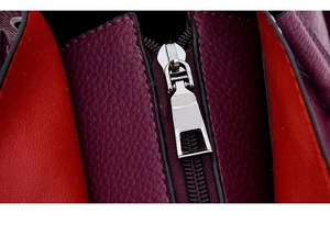Detailed macro of silver metal zipper and premium burgundy lychee pattern leather
