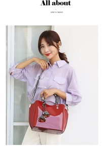 Detail of red patent leather handbag with snakeskin patterned straps and silver hardware