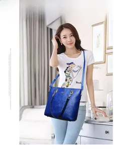 Close-up of royal blue tote bag with embossed rose pattern and gold chain link detail
