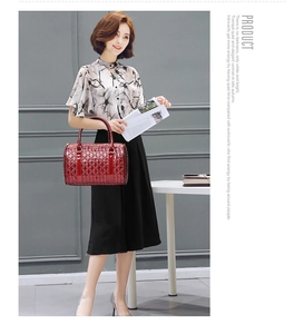 Detail of red patent leather handbag with embossed geometric diamond pattern and glossy finish